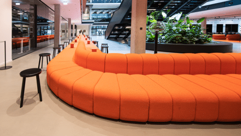 Ein auffälliges Merkmal des Gebäudes: ein riesiges orangenes Sofa im Eingangsbereich. © Serviceplan