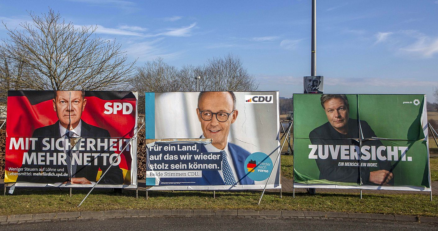 Wahlplakate zur Bundestagswahl am 23. Februar 2025: SPD Olaf Scholz "Mit Sicherheit mehr netto" - CDU Friedrich Merz "Für ein Land, auf das wir wieder stolz sein können" - Robert Habeck Die Grünen "Zuversicht". Dazu die Bildunterschrift: Die Plakate von SPD und Grünen rückten mit „Sicherheit“ und „Zuversicht“ einzelne Begriffe ins Zentrum, während die CDU einen Wirtschaftswahlkampf führen wollte. © picture alliance / HMB Media