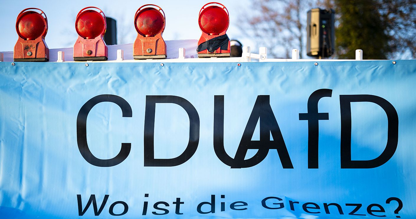 Schild mit "CDU und AfD - Wo ist die Grenze?" auf einer Demonstration für die Brandmauer in Vechta am 19. Februar 2025. Dazu die Bildunterschrift: Friedrich Merz betonte, dass es keine Zusammenarbeit mit der AfD geben werde. Vor allem Olaf Scholz versuchte, daran Zweifel zu säen. © picture alliance / Noah Wedel