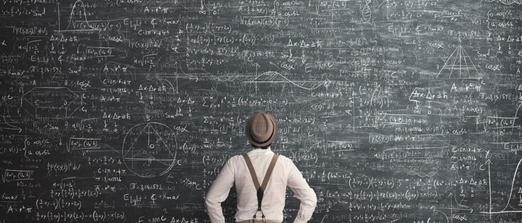 Ein Mann steht vor einer Kreidetafel, vollgeschrieben mit mathematischen Formeln. Dazu die Bildunterschrift: Sich kurz zu fassen, sei ein strategischer Imperativ, meint unser Autor. © Getty Images/francescoch
