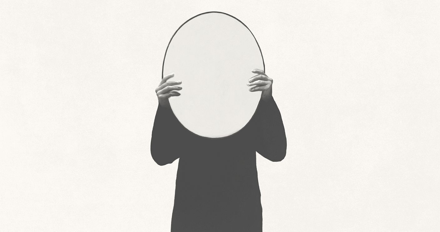 Illustration einer Person, die einen Spiegel vor ihr Gesicht hält. Dazu die Bildunterschrift: Wie können Führungskräfte Orientierung geben, wenn sie selbst gerade keine haben? © Getty Images/francescoch