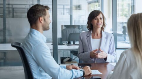 Meeting von drei Personen, zwei Frauen und einem Mann, in einem modernen Büro.