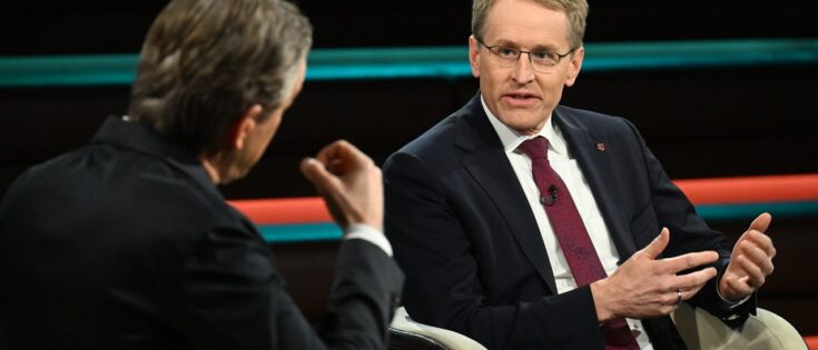 Markus Lanz und Daniel Günther sitzen in einem Studio und diskutieren. Beide tragen formelle Kleidung.