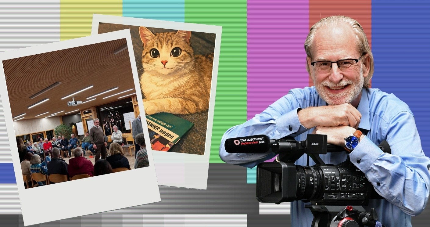 Ein lächelnder Mann mit Kamera umarmt ein Polaroid-Foto von einer Menschenmenge und einer Katze auf einem Buch.