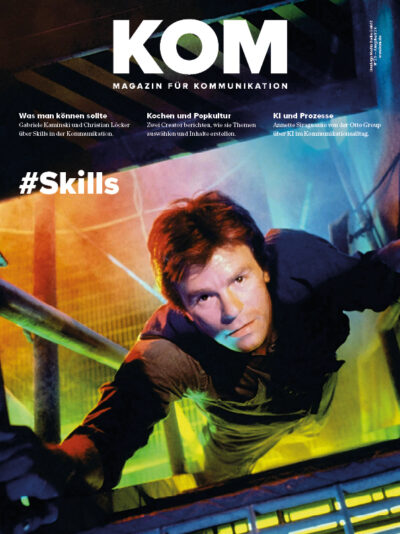 Mann in neonbeleuchtetem Raum, schaut direkt in die Kamera, Titel "KOM" und Hashtag "#Skills" prominent platziert.