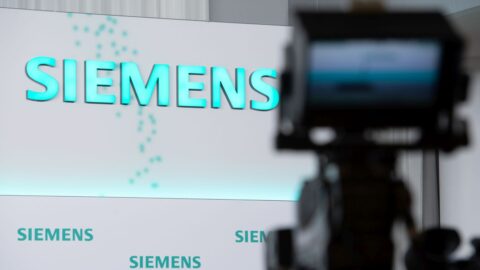 Siemens-Logo auf einer Bühne, im Vordergrund eine Kamera, bereit für die Pressekonferenz am 12. November 2020.