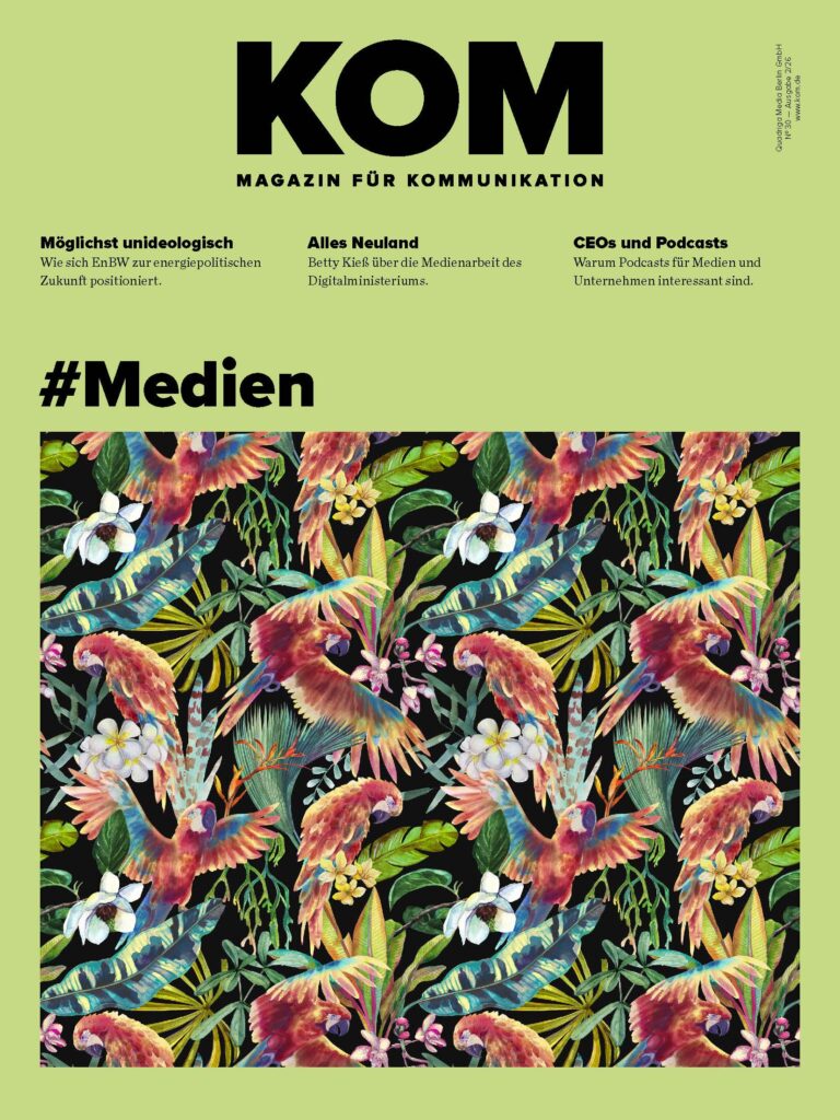 Cover of KOM Magazin für Kommunikation with lime background, oversized black 'KOM', three article teasers, and a colorful tropical floral border at the bottom.
