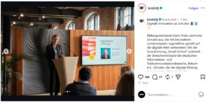 © Screenshot Instagram/@bmbfsfj | KOM - Magazin für Kommunikation Frau am Rednerpult präsentiert auf einer Bühne, im Hintergrund ein Bildschirm mit Informationen zur digitalen Bildung.
