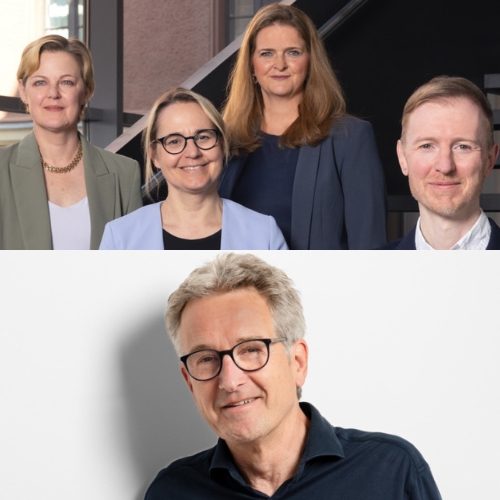 Vier Personen in formeller Kleidung, lächelnd, stehen zusammen vor einem modernen Hintergrund.