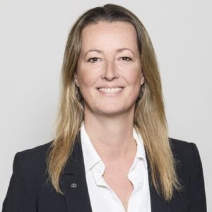 Porträt von Sabine Medefindt in einem schwarzen Blazer mit bluse, lächelnd vor neutralem Hintergrund.
