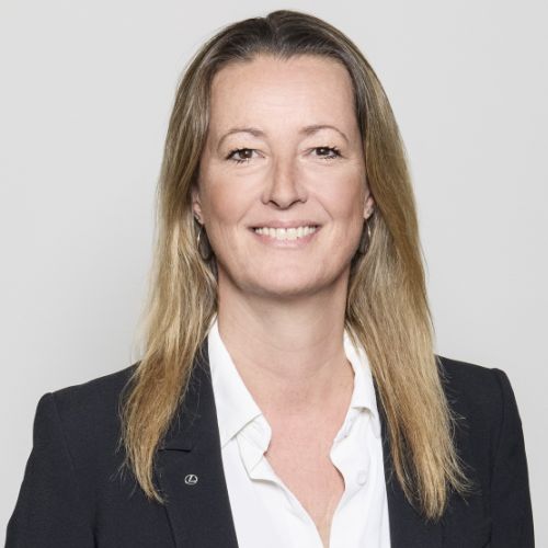 Porträt von Sabine Medefindt in einem schwarzen Blazer mit bluse, lächelnd vor neutralem Hintergrund.
