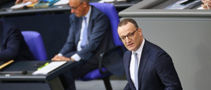 Friedrich Merz und Jens Spahn sprechen im Deutschen Bundestag während einer Sitzung.