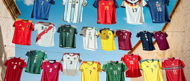 Verschiedene Fußballtrikots hängen an einer Wäscheleine vor blauem Himmel.