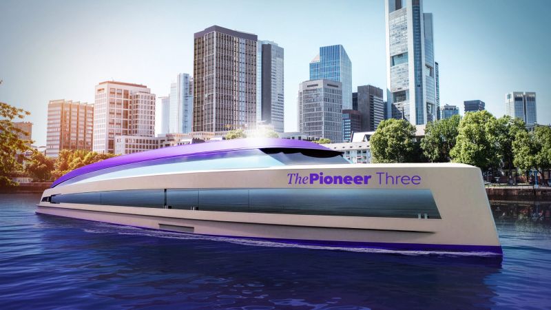 Modernes Schiff "The Pioneer Three" im Wasser, umgeben von einer Stadtlandschaft mit hohen Gebäuden.
