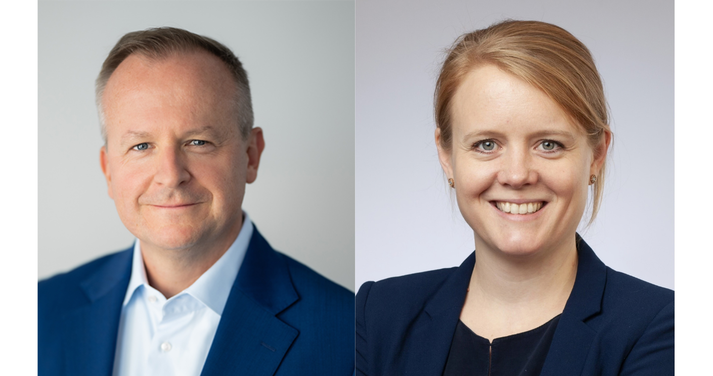 Zwei Personen in Anzügen, lächelnd, vor neutralem Hintergrund; links ein Mann, rechts eine Frau.